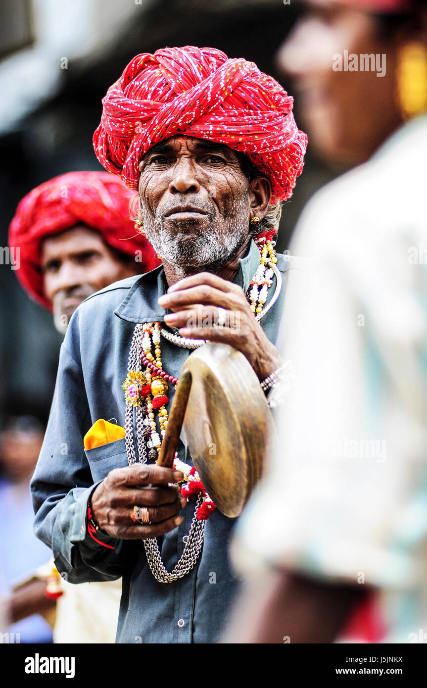 Udaipur, India, september 14, 2010: Old indian man in turban playing music with his group on a street. Stock Photo