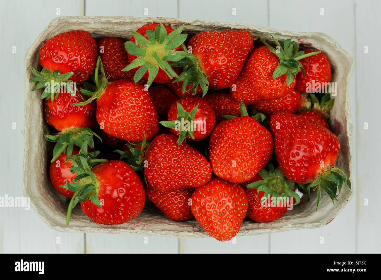 Strawberries in a basket on wooden whitstable, top view Stock Photo
