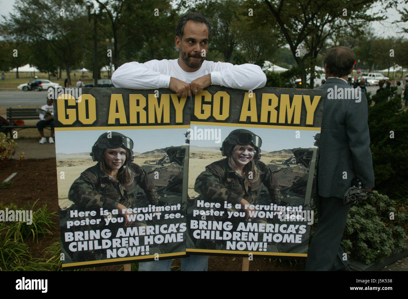 A protester displays protest signs depicting the Bush twins as the models for an Army recruiting advertisement the anti-war march on Washington. Stock Photo