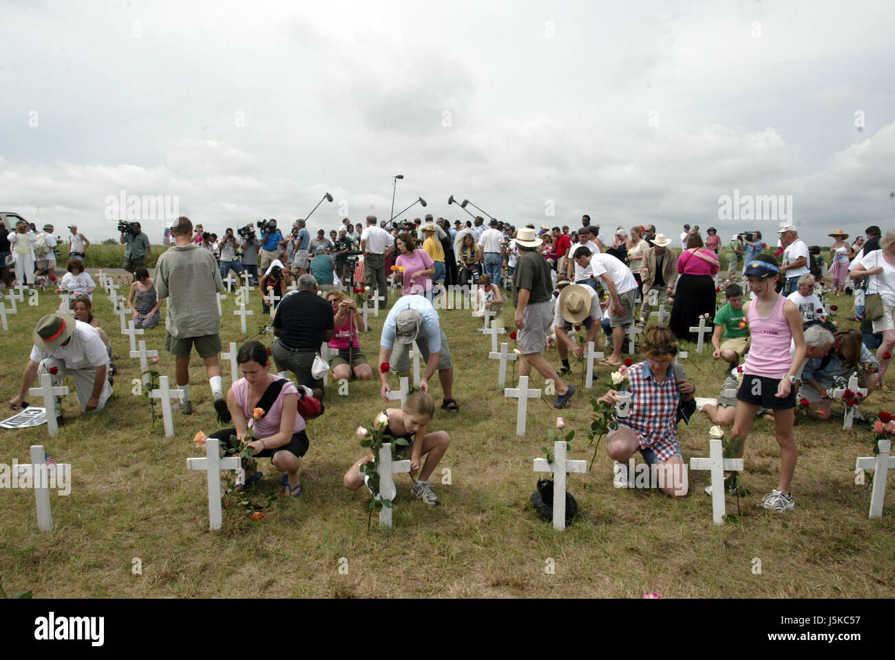 As anti-war activists and family members of U.S. solders killed in Iraq place flowers on crosses the media swarms around Cindy Sheehan and the Reverend Al Sharpton Jr. in the background at Camp Casey II. (Photo by Jeremy Hogan)Protests against George W Bush take place near his home in Crawford, Texas over the summer of 2005. Anti-War activist Cindy Sheehan had begun the protests after her son Casey Sheehan was killed in Iraq during the U.S. invasion. Sheehan demanded that Bush talk to her about the war, and when he didn't, she set up a protest outside his ranch. Stock Photo