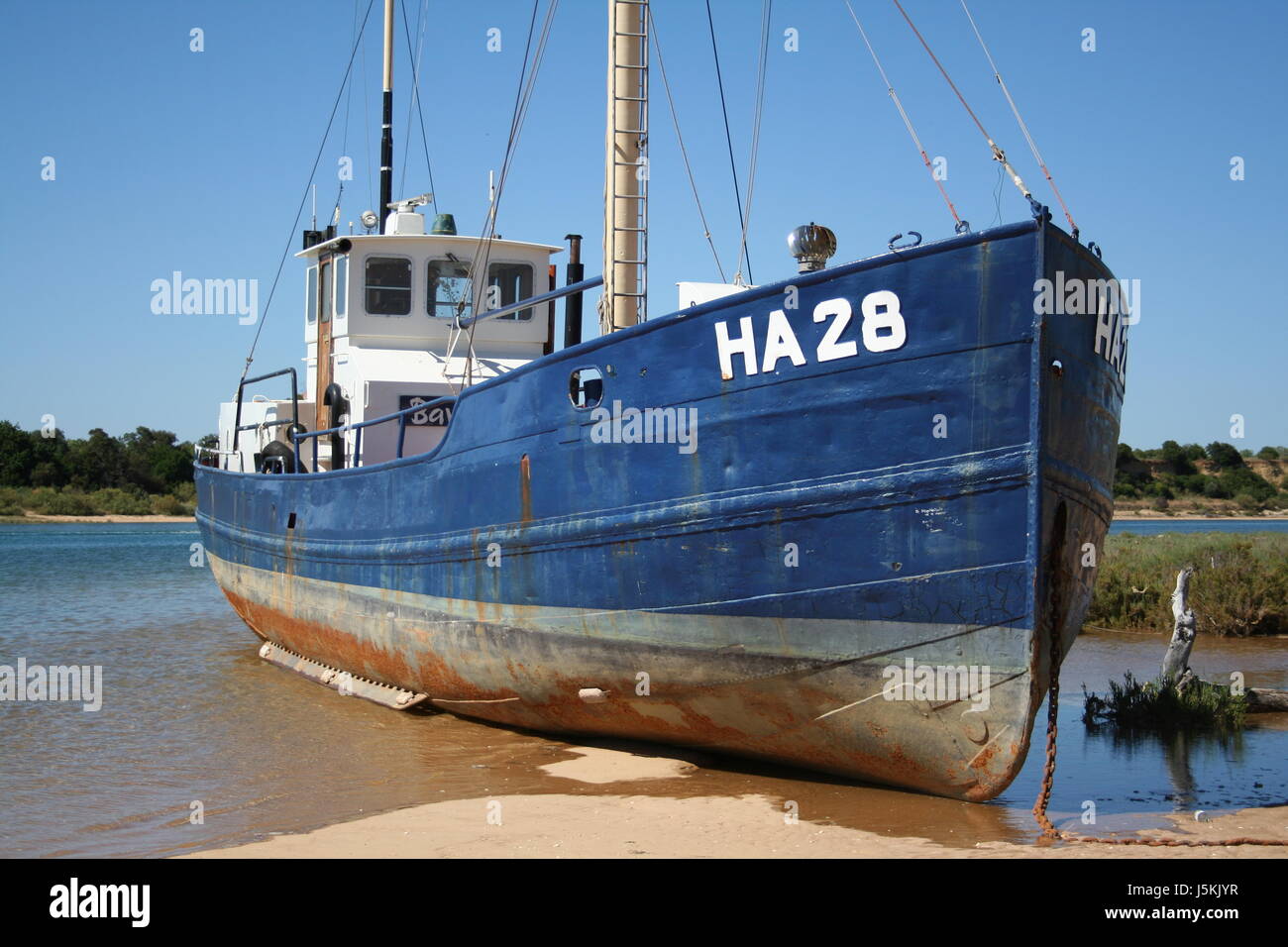 fishing boat at low tide Stock Photo - Alamy