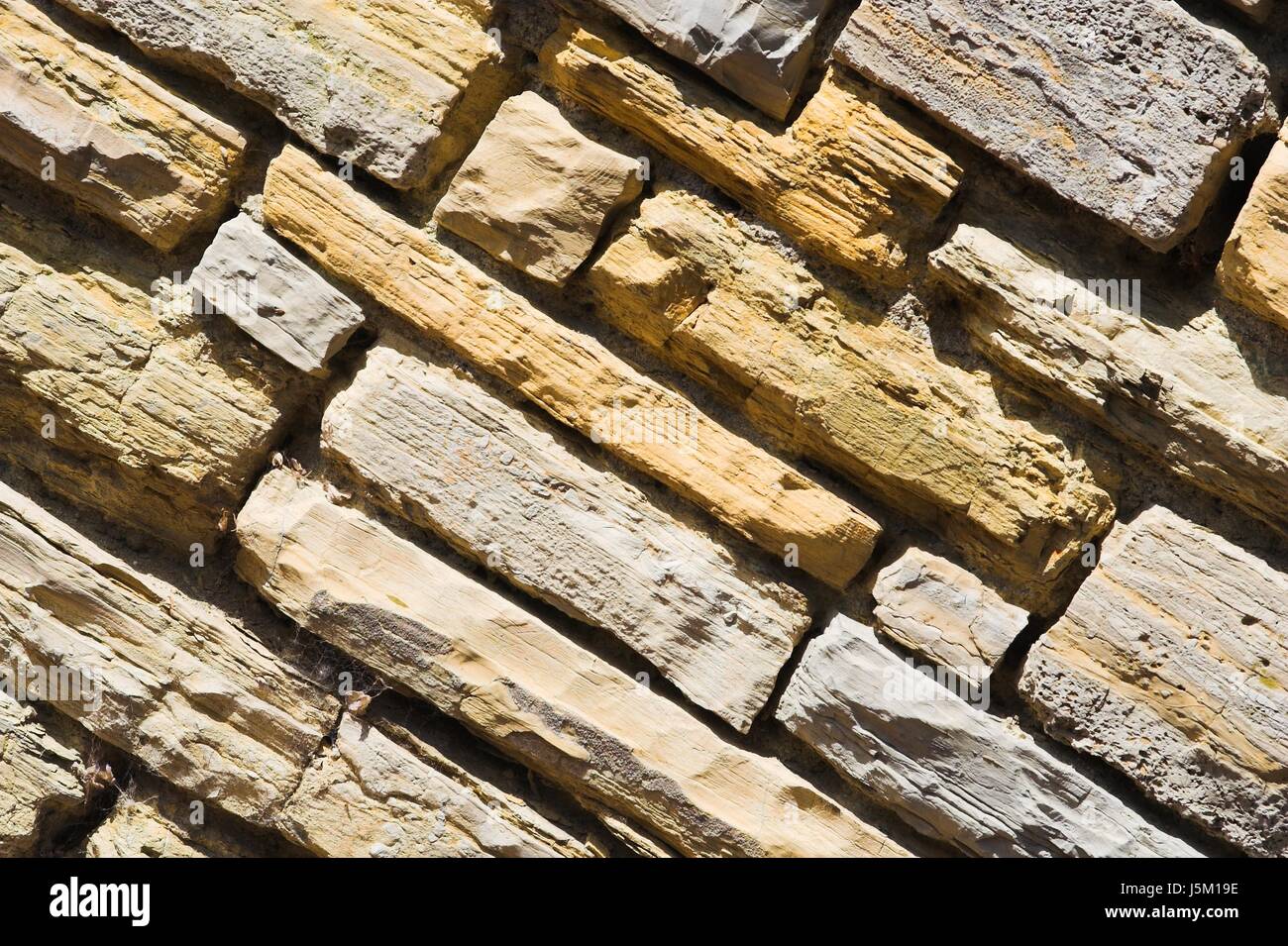 oblique sandstone beige quadrangular ocher natural stone backdrop background Stock Photo