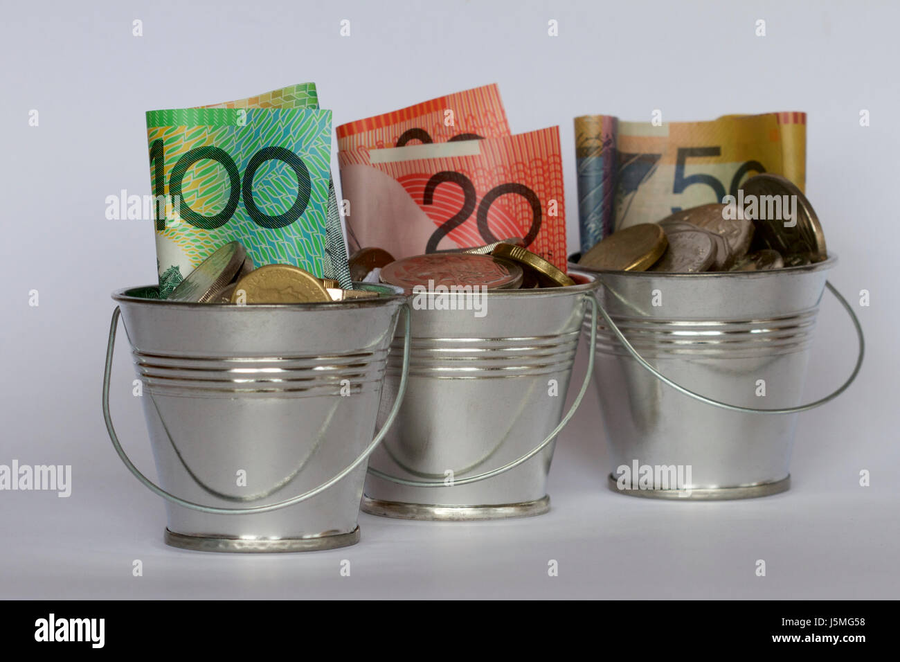 Australian dollars and coins in three buckets. Stock Photo