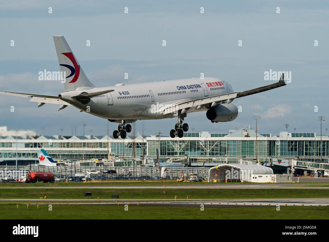 China Eastern Airlines plane airplane landing Vancouver International Airport terminal exterior view Airbus A330 jetliner Stock Photo