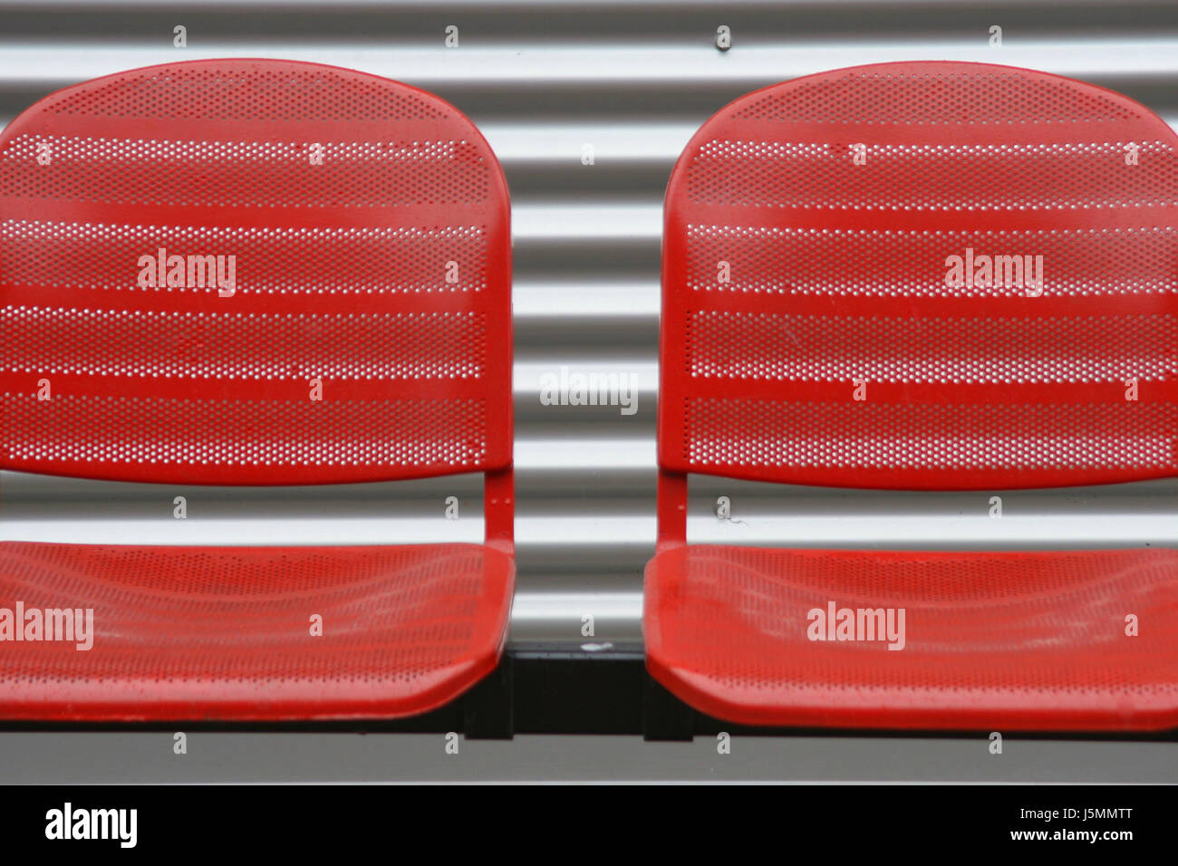 red seats in front metal wall Stock Photo Alamy