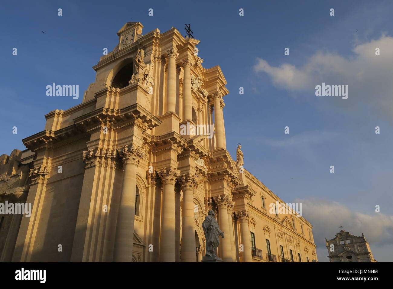 A mighty church in a square in Ortigia city on Sicily island in Italy. Very rick, decorated facade, columns in brown colour Stock Photo