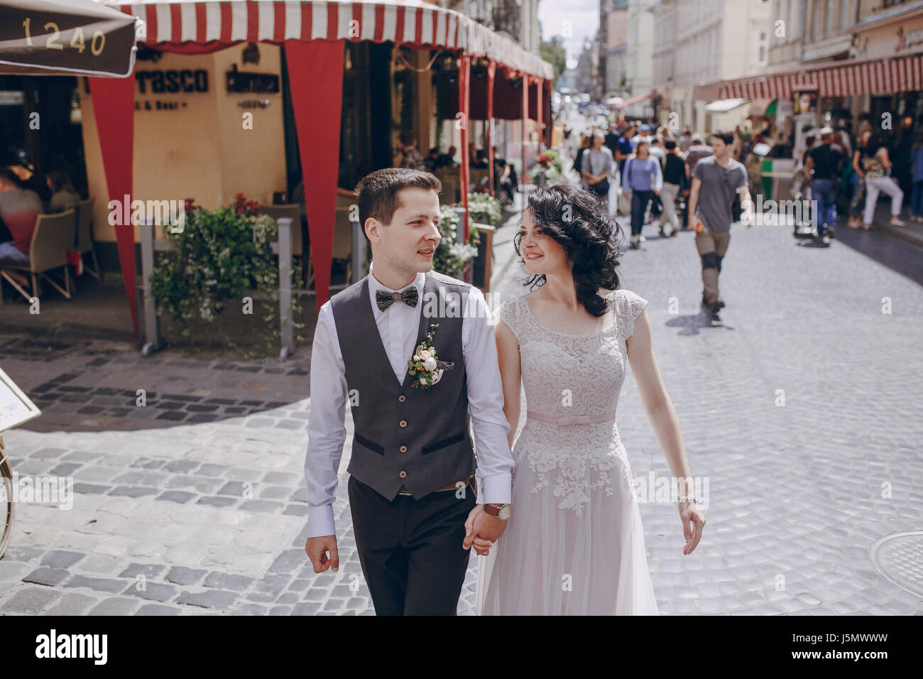 bride and groom walking along a sunny city Stock Photo - Alamy