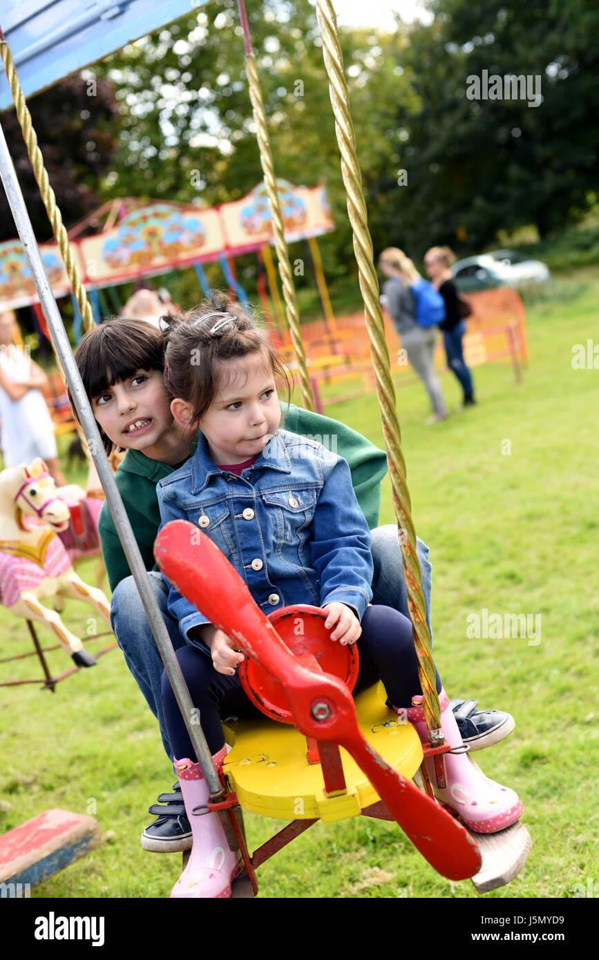 Brother and Sister on plane fairground ride (Brighton Apple Day, Stanmer Park, Stock Photo