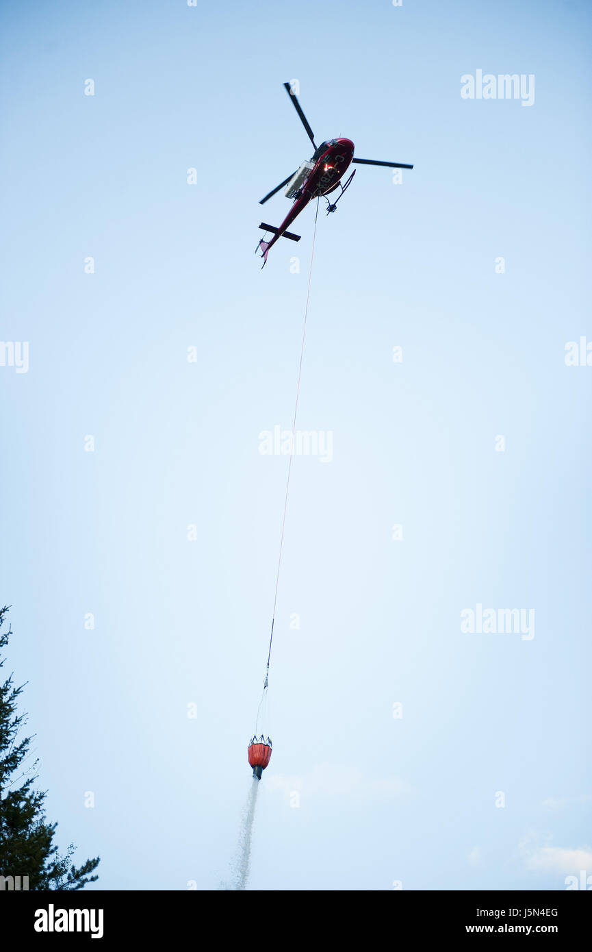 A350 AStar helicopters drop water from bucket slung underneath during