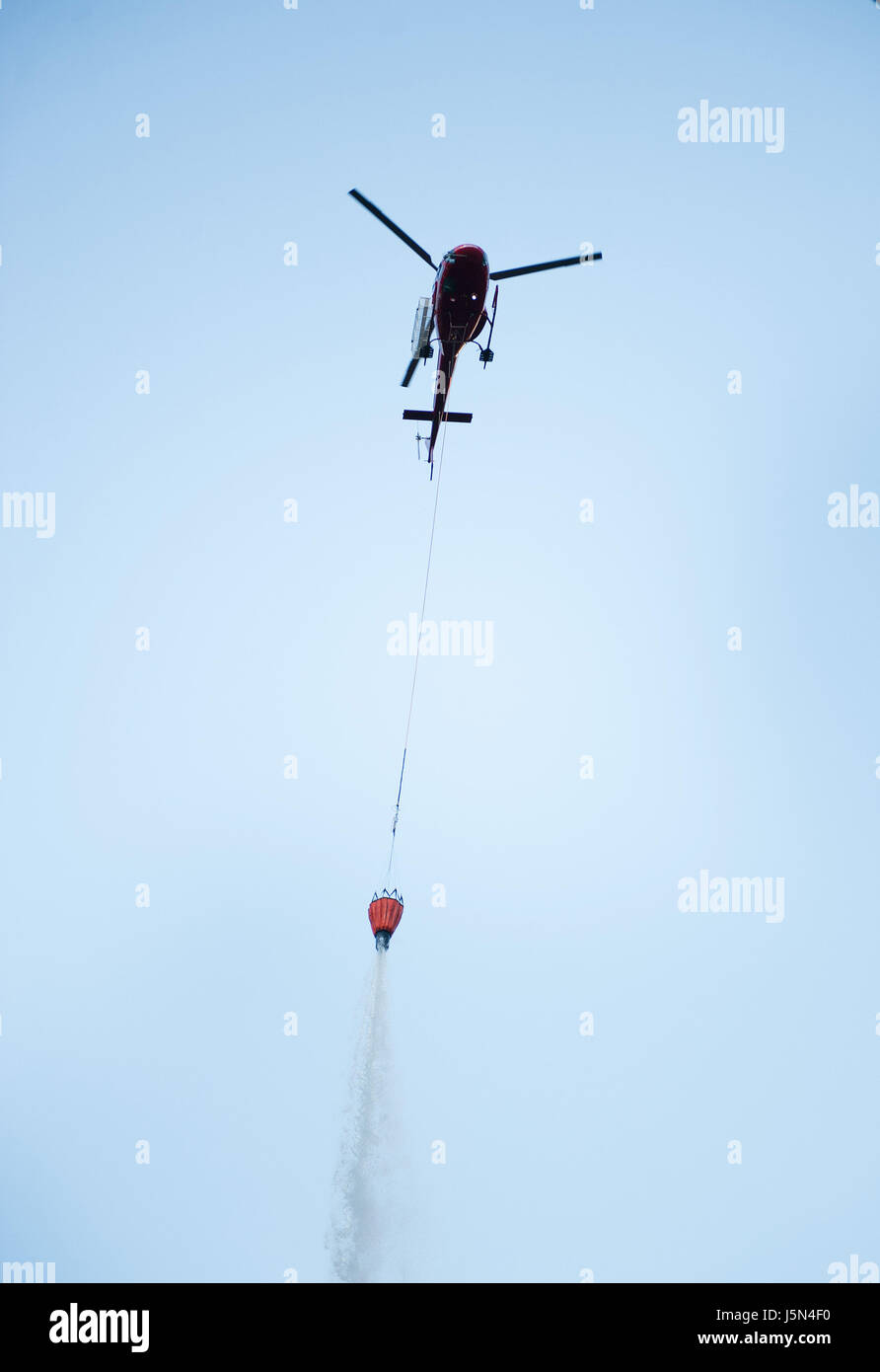 A350 AStar helicopters drop water from bucket slung underneath during