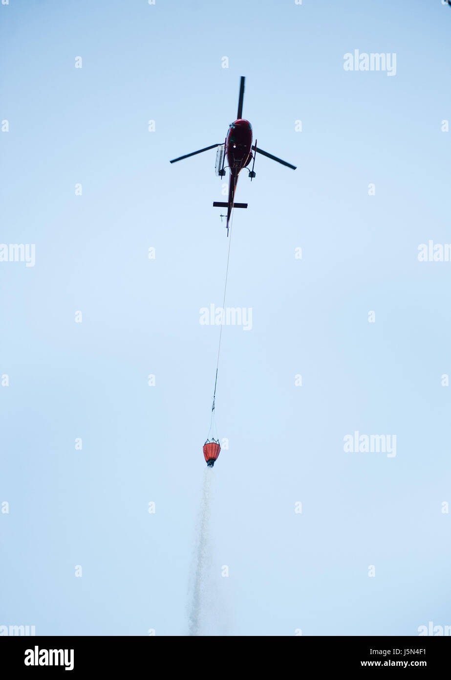 A350 AStar helicopters drop water from bucket slung underneath during