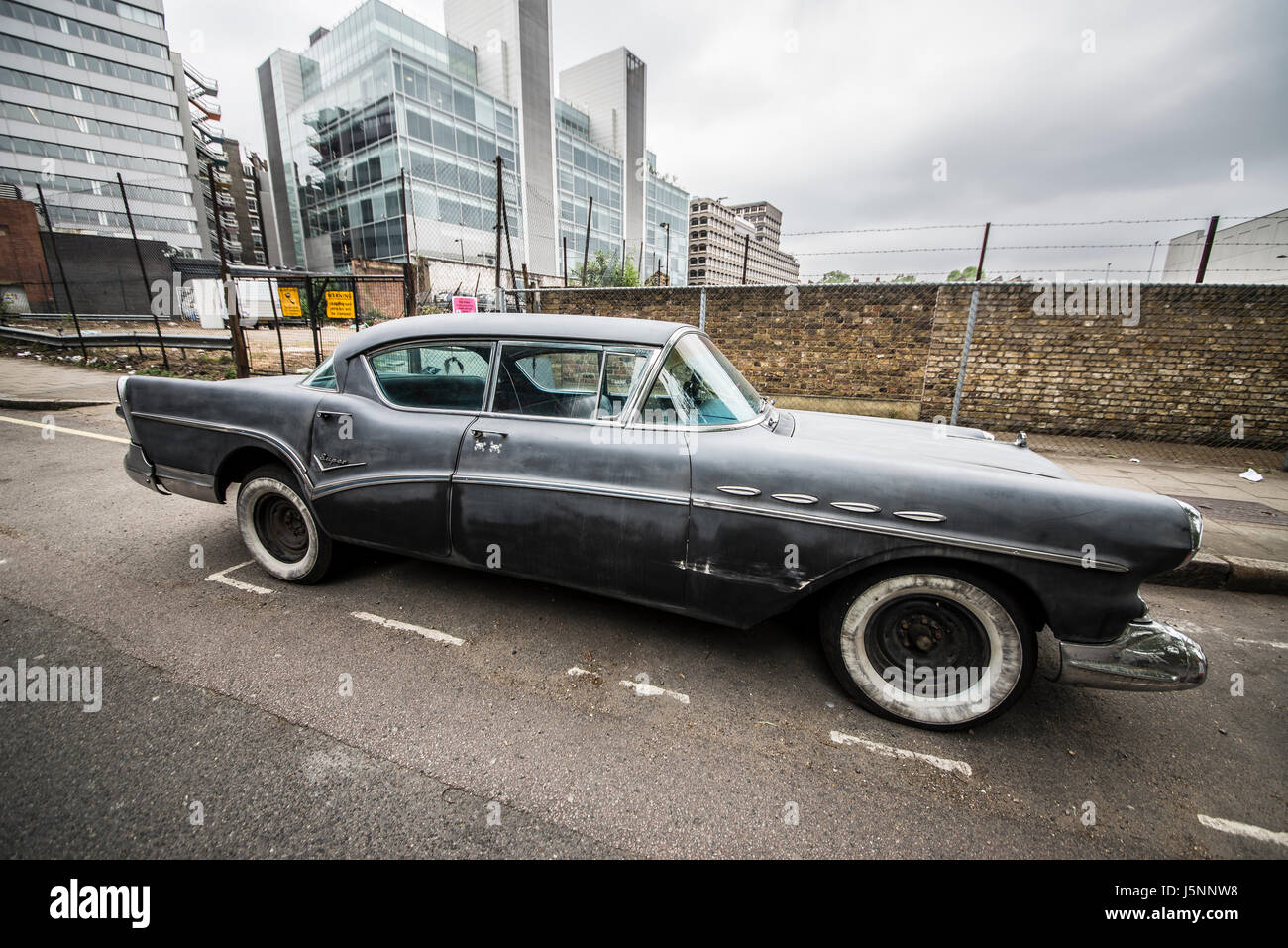 Aging 1950s (1956 ?) Buick Super Riviera in a London side street. With whitewall tyres / tires. Decay Stock Photo