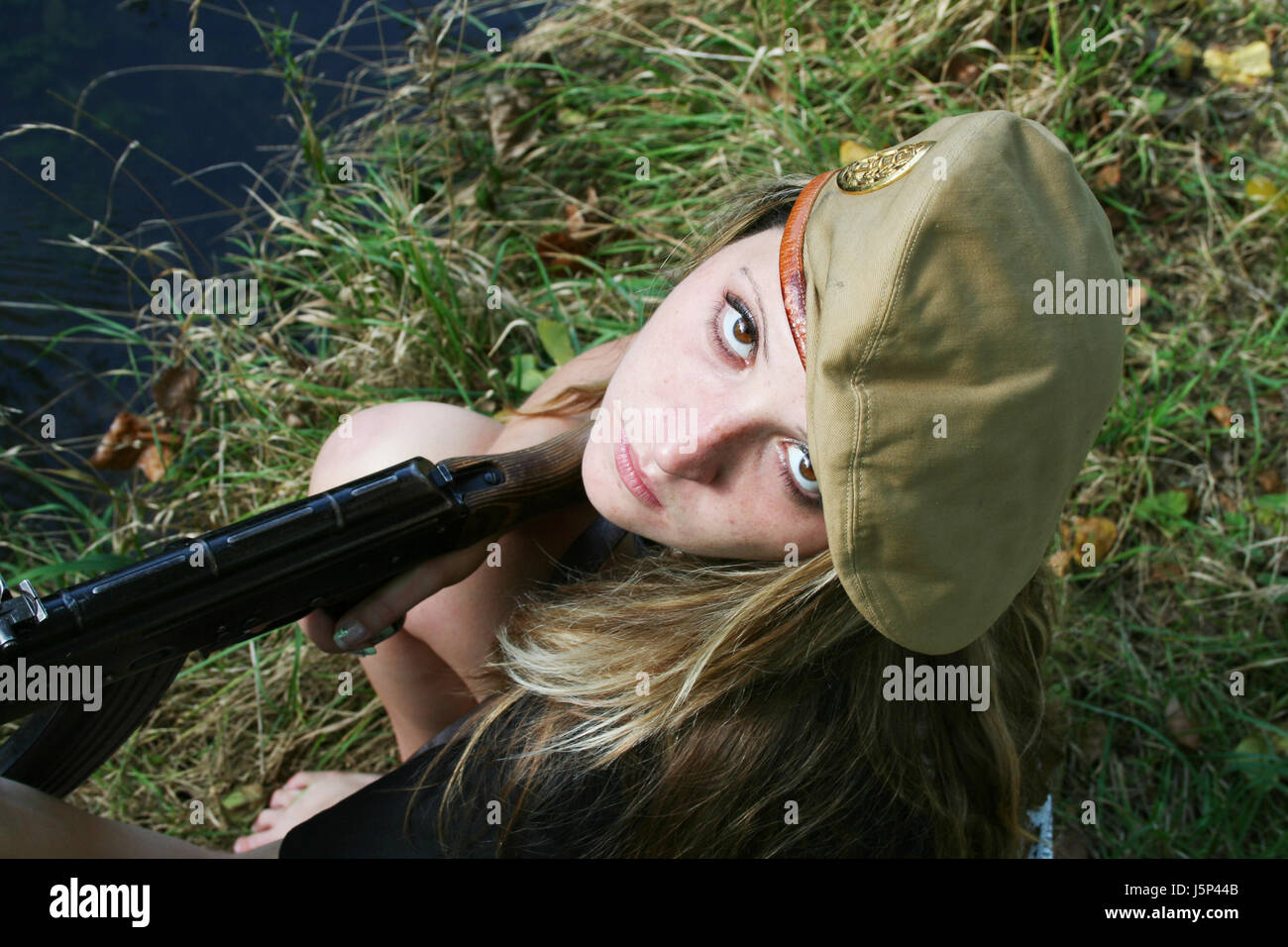 woman with gun looks upwards Stock Photo