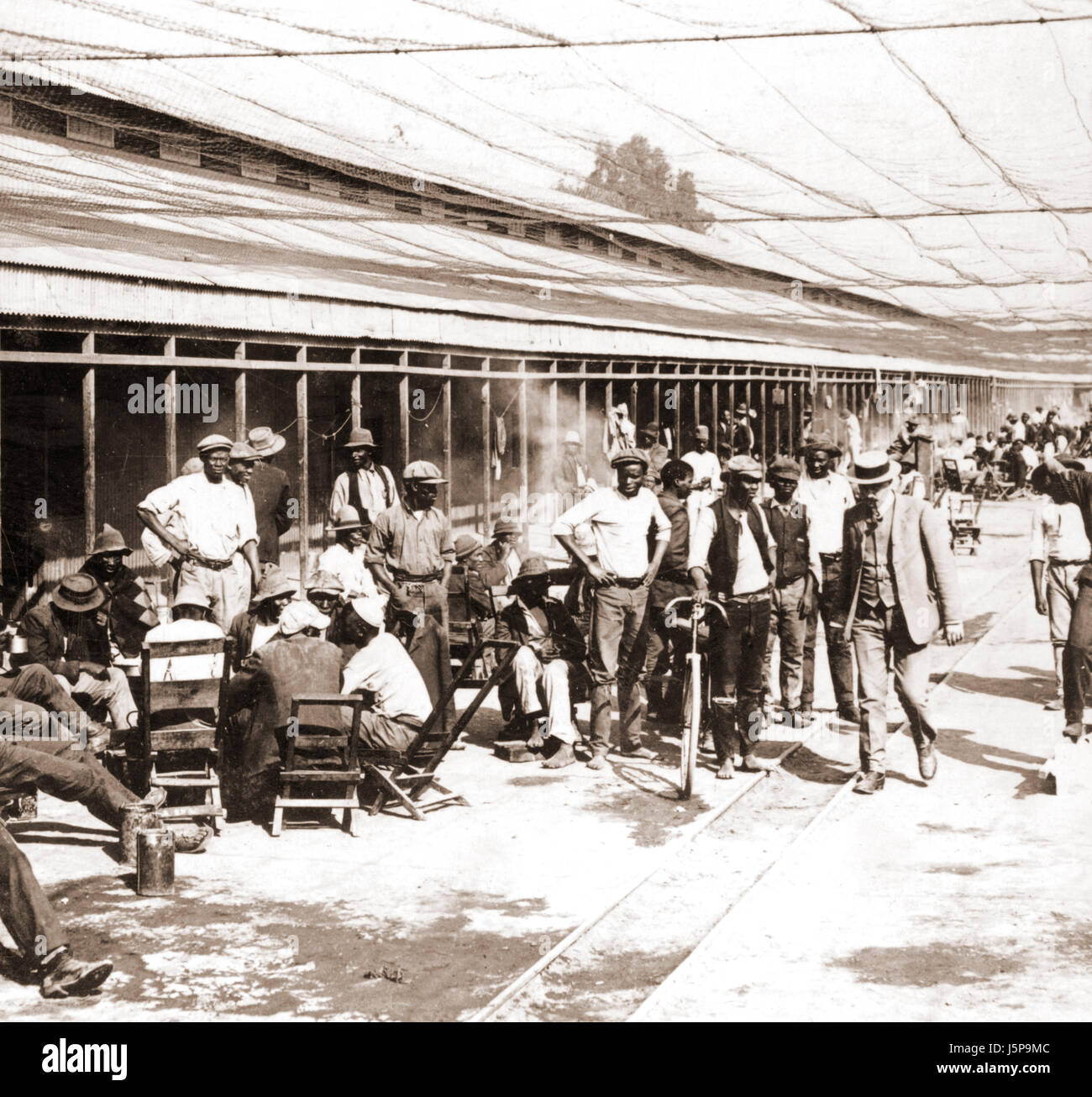 Workers in compound enclosed by wire netting, De Beer's Diamond Mines, Kimberley, about 1900 Stock Photo