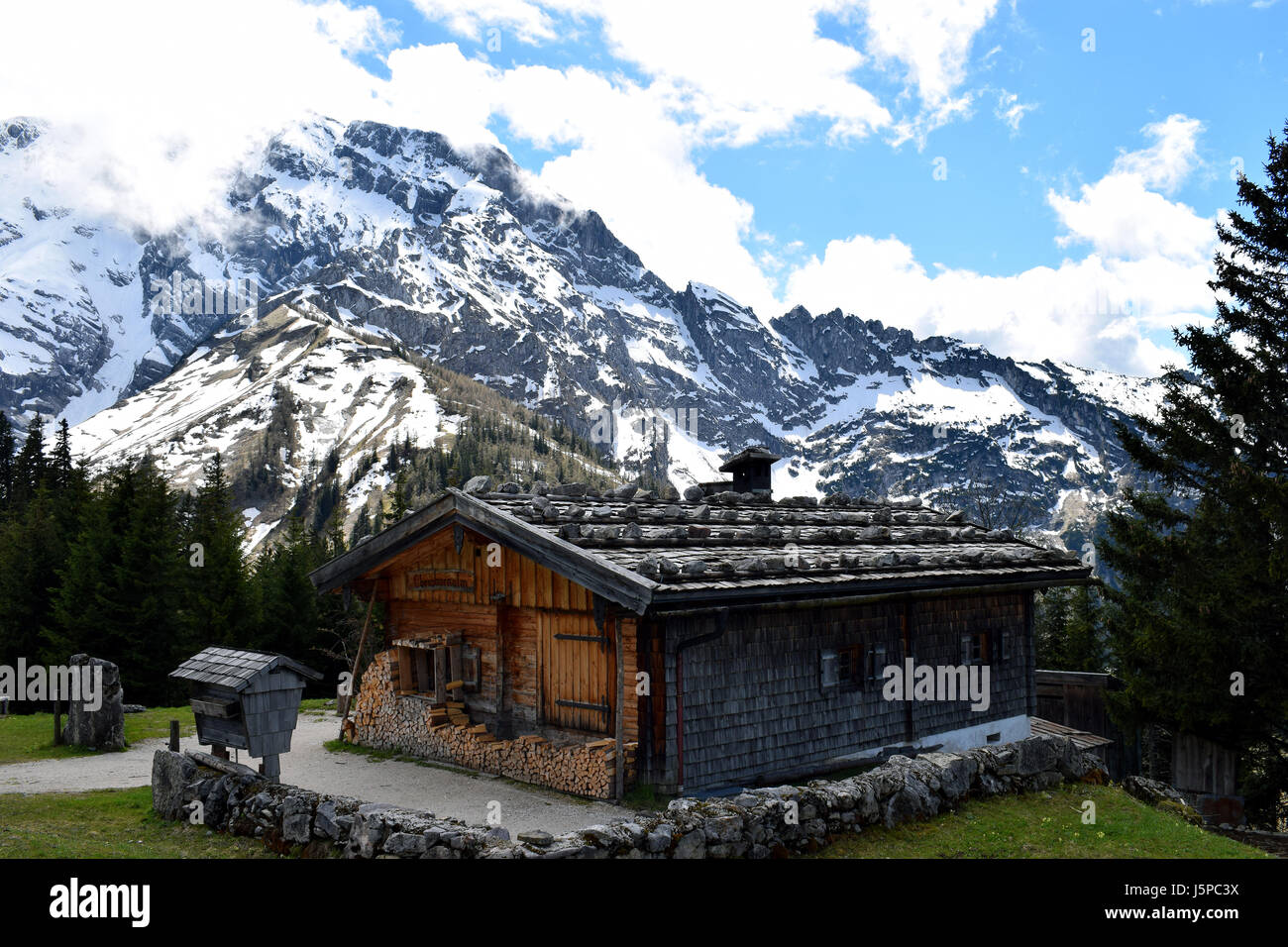 Beautiful alpine landscape with snow-capped mountains and old shingle mountain hut on Rossfeldstrasse panorama road near Berchtesgaden, Germany. Stock Photo