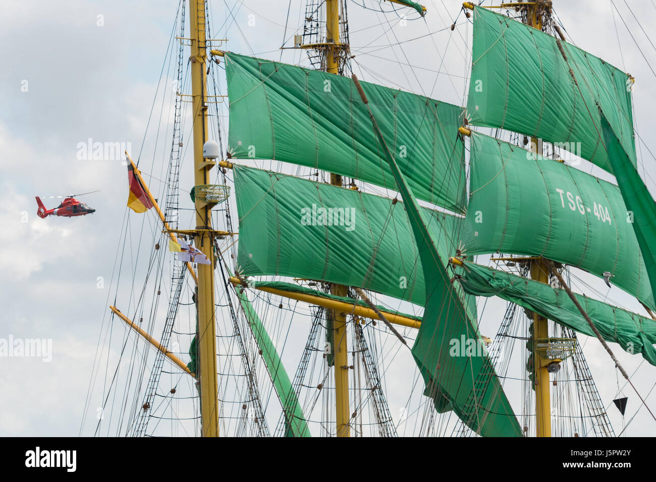 Charleston, USA. 18th May, 2017. A U.S. Coast Guard helicopter flies past the massive sails of the German Barque Alexander von Humboldt II during the parade of sails kicking off the Tall Ships Charleston festival May 18, 2017 in Charleston, South Carolina. The festival of tall sailing ships from around the world will spend three-days visiting historic Charleston. Credit: Planetpix/Alamy Live News Stock Photo