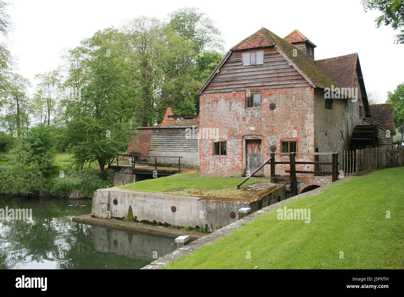 house building tree trees green stream england mill browse waterpower meadow Stock Photo