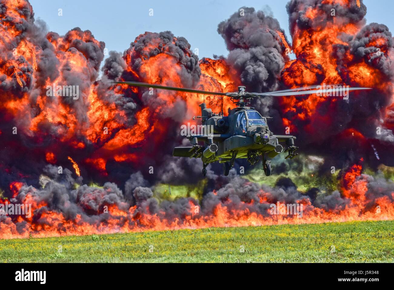 A U.S. Army AH-64D Apache attack helicopter flies in front of a wall of fire during the South Carolina National Guard Air and Ground Expo at the McEntire Joint National Guard Base May 6, 2017 in Hopkins, South Carolina.    (photo by Jorge Intriago /US Airforce Photo via Planetpix) Stock Photo