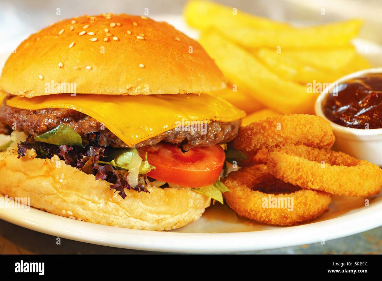 Burger, french fries and onion rings with barbeque sauce Stock Photo