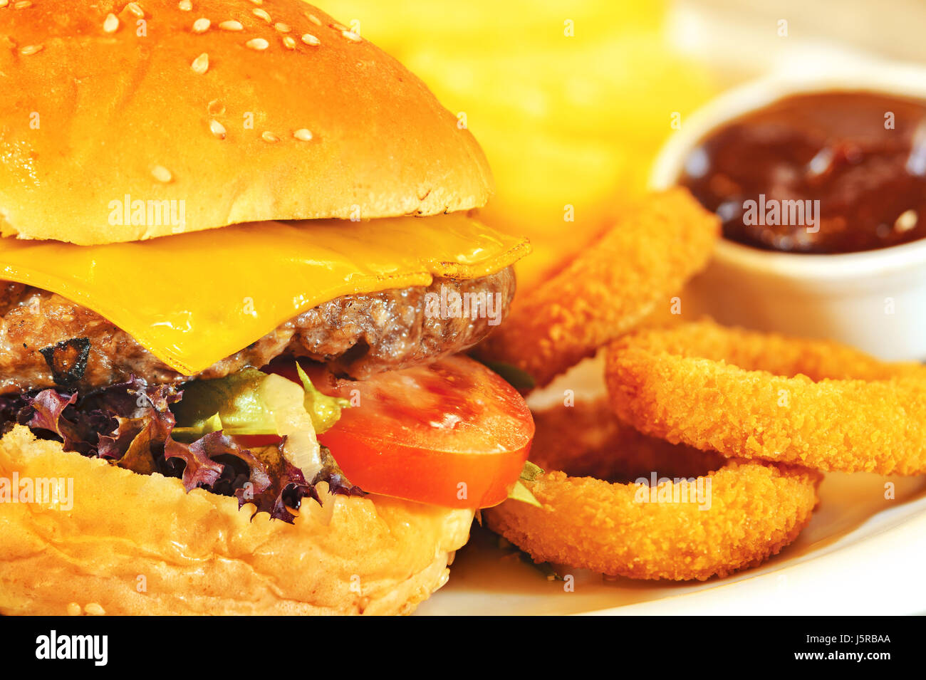 Burger, french fries and onion rings with barbeque sauce Stock Photo