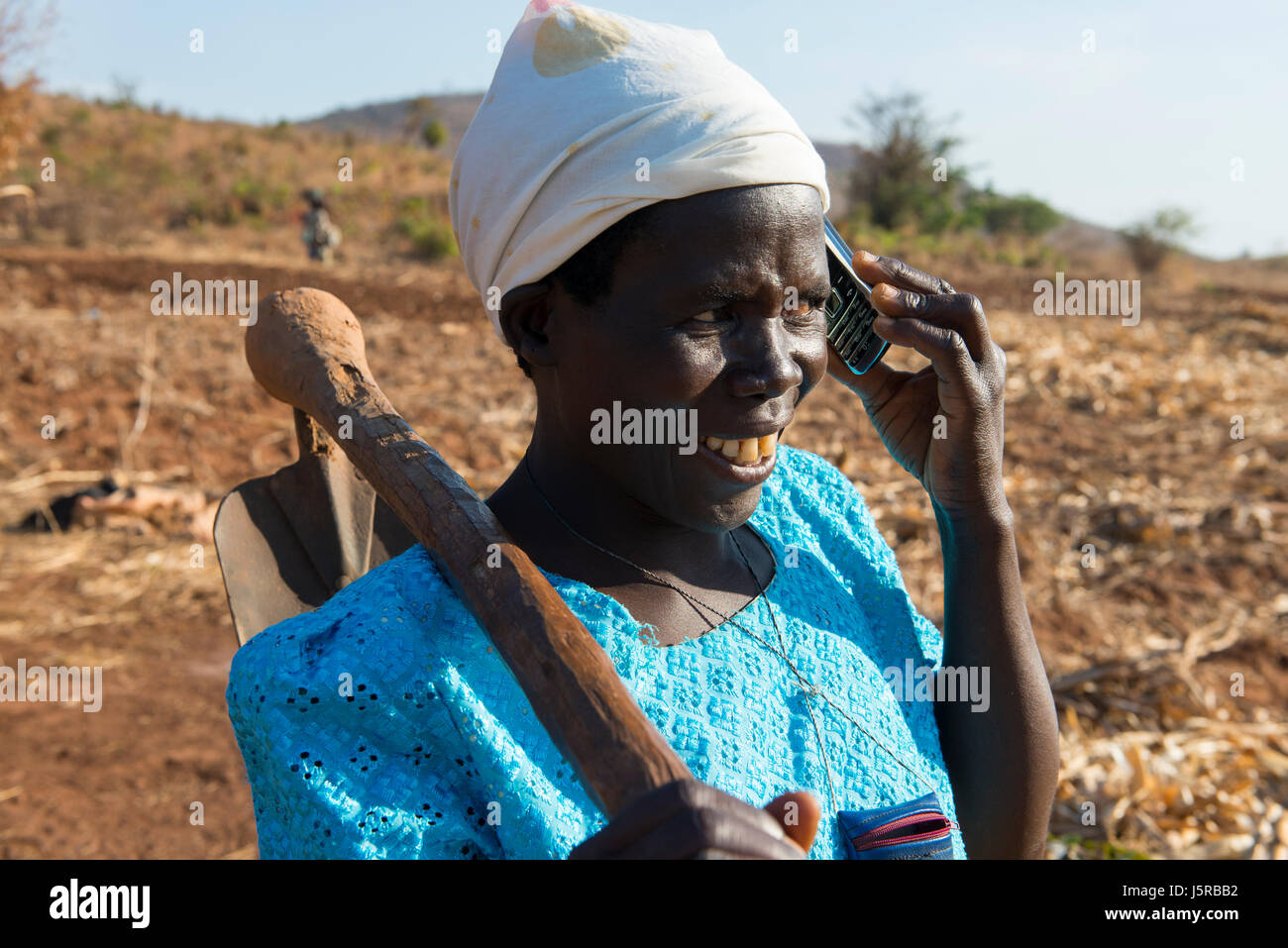 MALAWI, village Zingiziwa, woman with hoe and mobile phone / MALAWI, Dorf Zingiziwa, Farmerin mit Hacke und Mobiltelefon Stock Photo