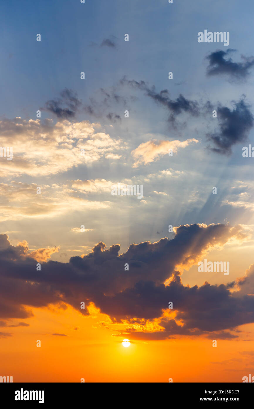 Vertical sunset with rays of light, with heavy orange and blue accents Stock Photo