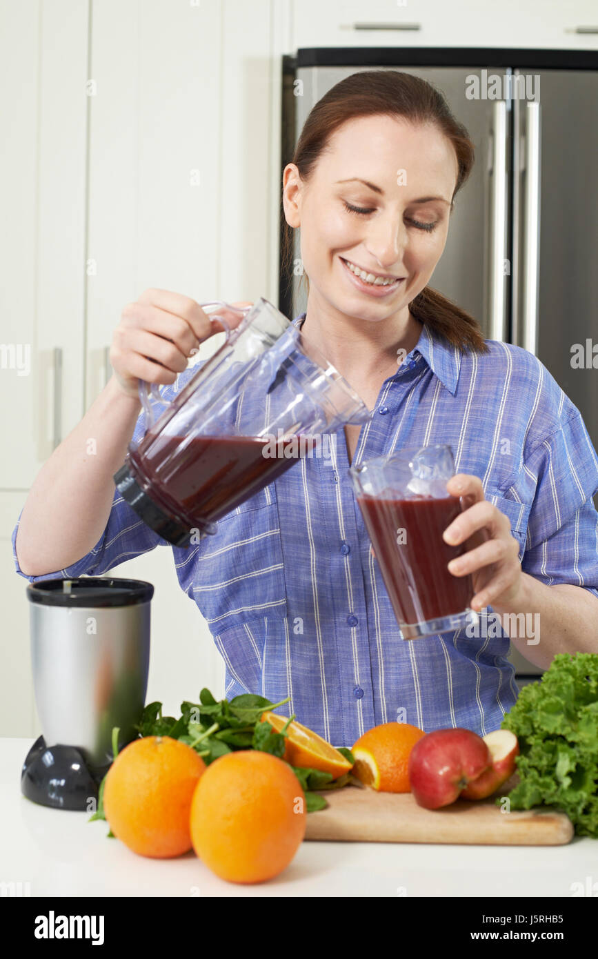 Woman Making Juice Or Smoothie In Kitchen Stock Photo Alamy