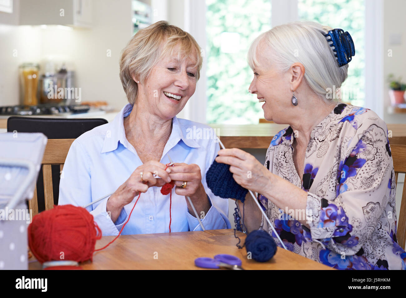 Two Senior Female Friends Knitting At Home Together Stock Photo Alamy