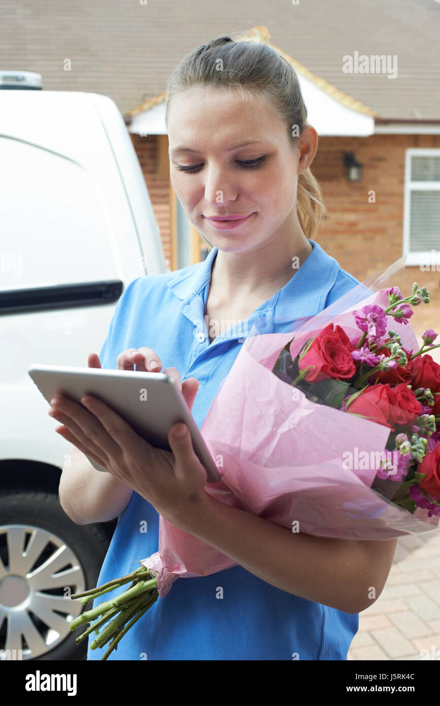 Florist With Digital Tablet Making Home Delivery Of Bouquet Stock Photo