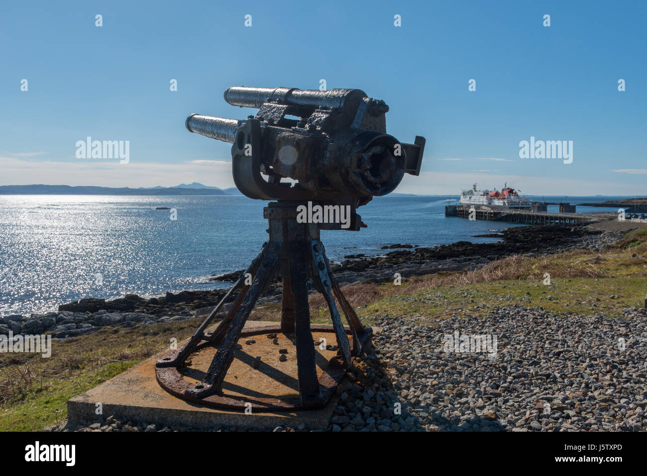 Old 90mm Gun overlooking the ferry terminal on The Inner Hebridean island of Coll Stock Photo