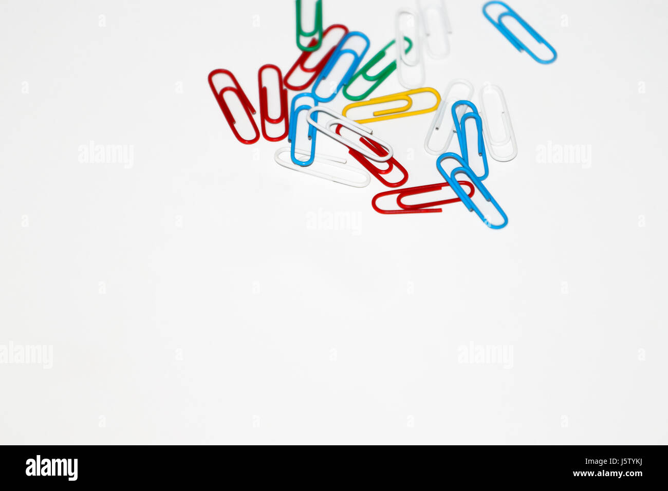 Colored paper clips on white background Stock Photo