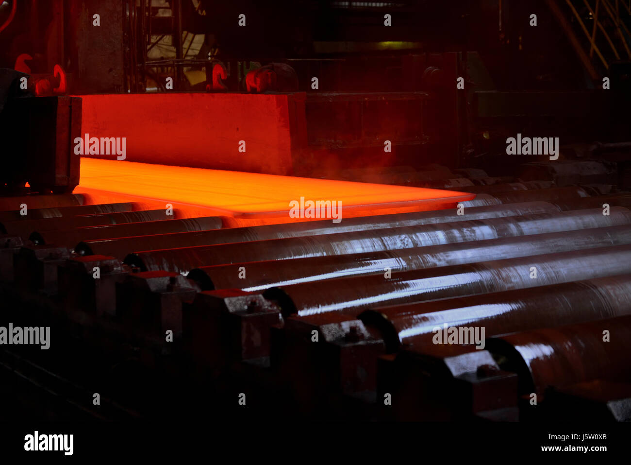 Hot steel plate on conveyor inside of steel plant Stock Photo