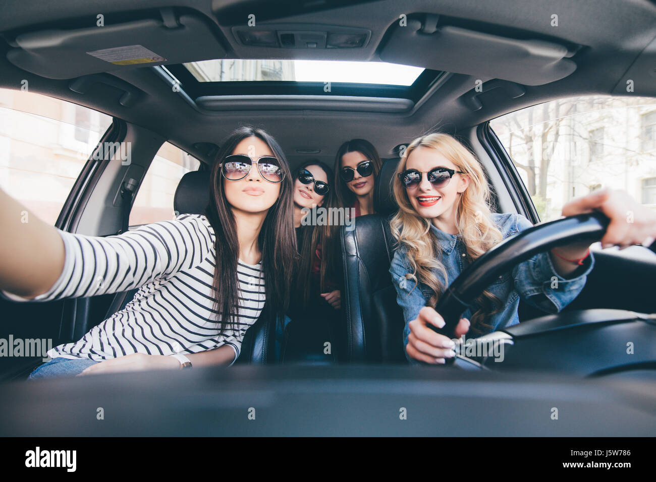 Group Of Girls Having Fun In The Car And Taking Selfies With Camera 