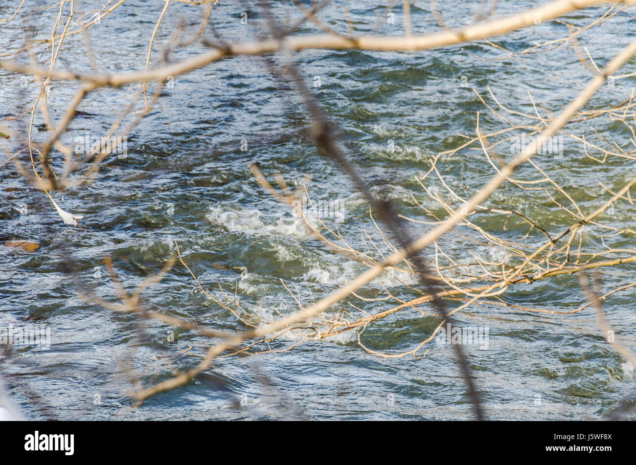 River flowing in winter with landscape of ground and tree covered in ...