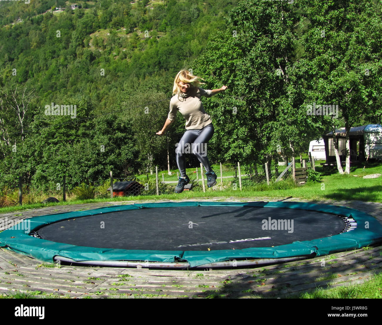 Young girl jumping on trampoline hires stock photography and images