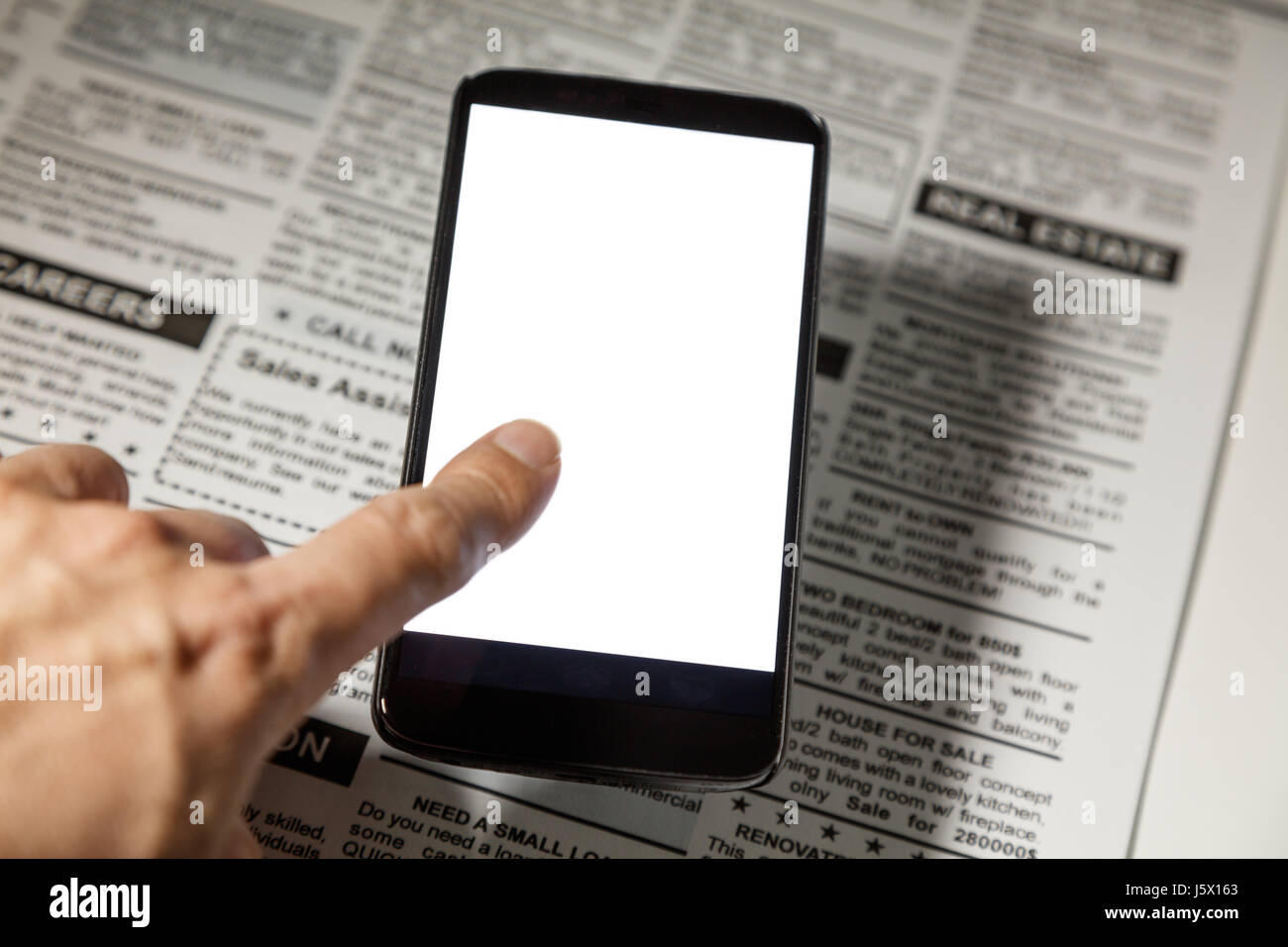 Fake newspaper and smartphone with blank screen. business communication concept. Stock Photo