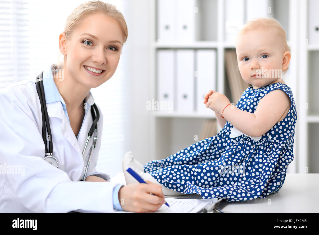 Pediatrician is taking care of baby in hospital. Little girl is being ...