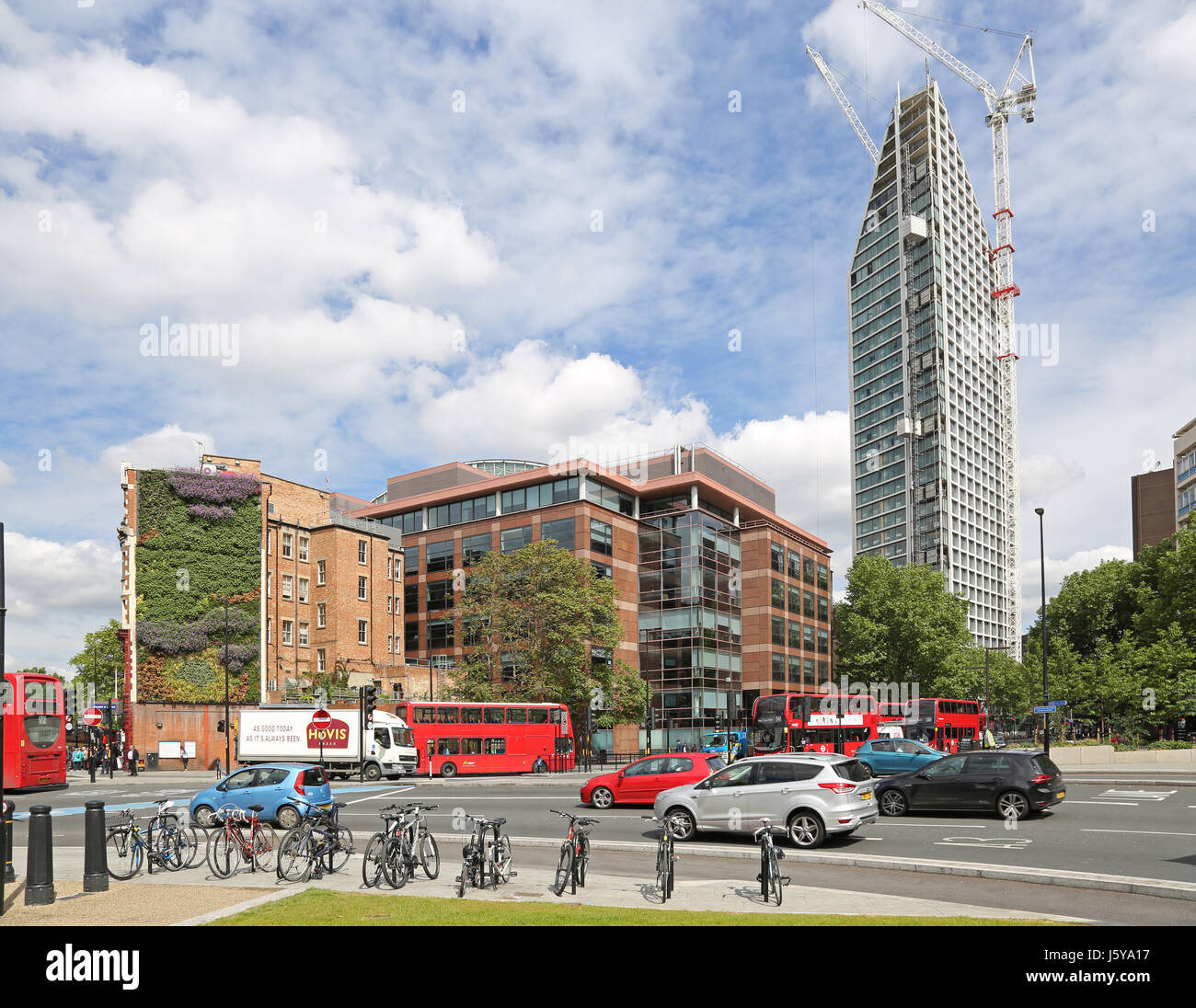 traffic flows round the newly remodelled road layout at London's Elephant and Castle junction. Shows new apartment block under construction beyond. Stock Photo