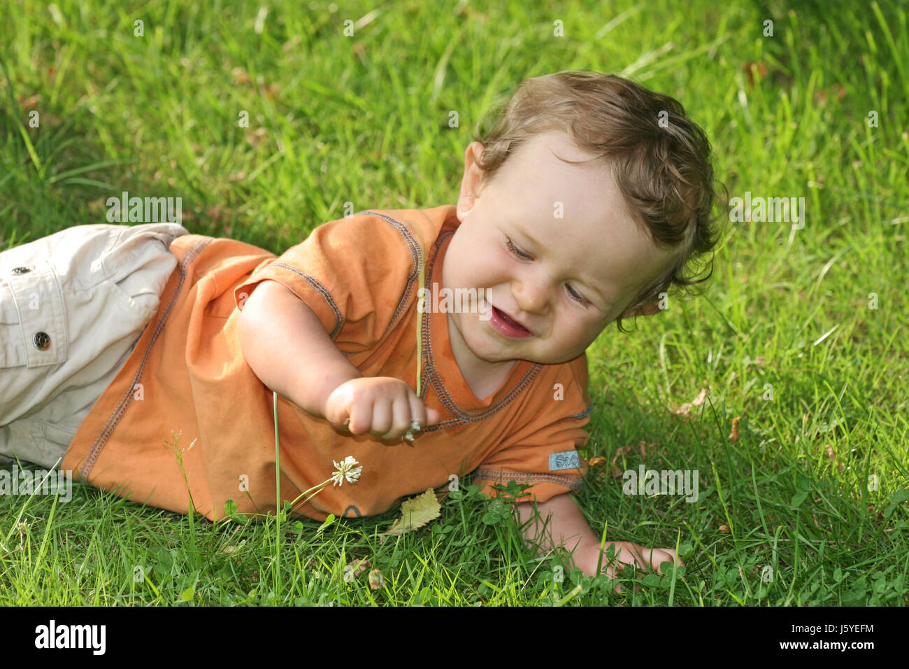 summer summerly lie lying lies baby grasp delighted unambitious enthusiastic Stock Photo