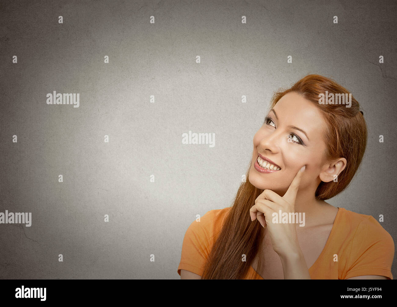 Portrait happy beautiful woman thinking looking up smiling isolated ...