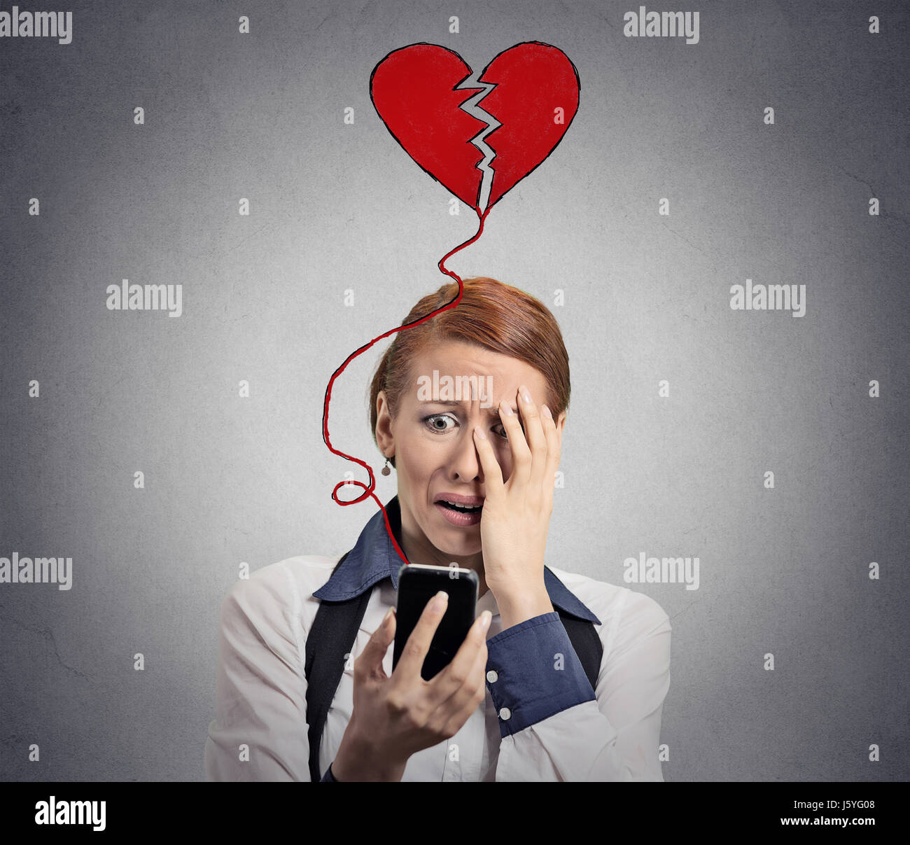 Sad woman with broken heart looking at her mobile phone isolated ...