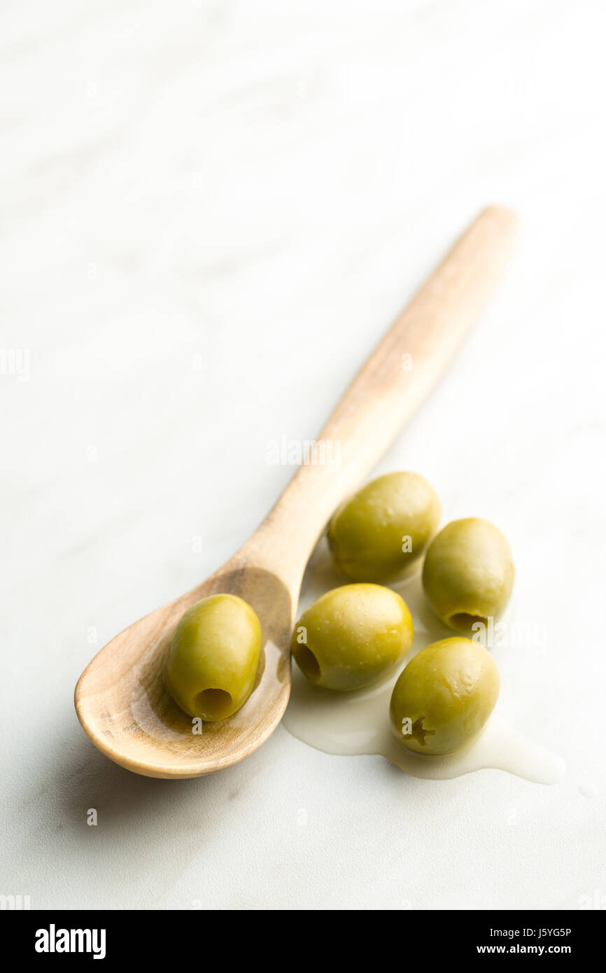 The green olives in wooden spoon Stock Photo - Alamy