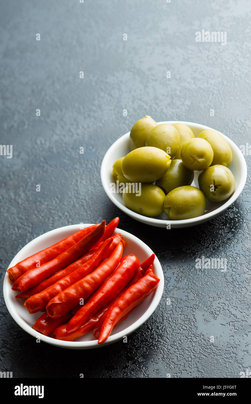 Pickled chili peppers and green olives in bowl Stock Photo Alamy