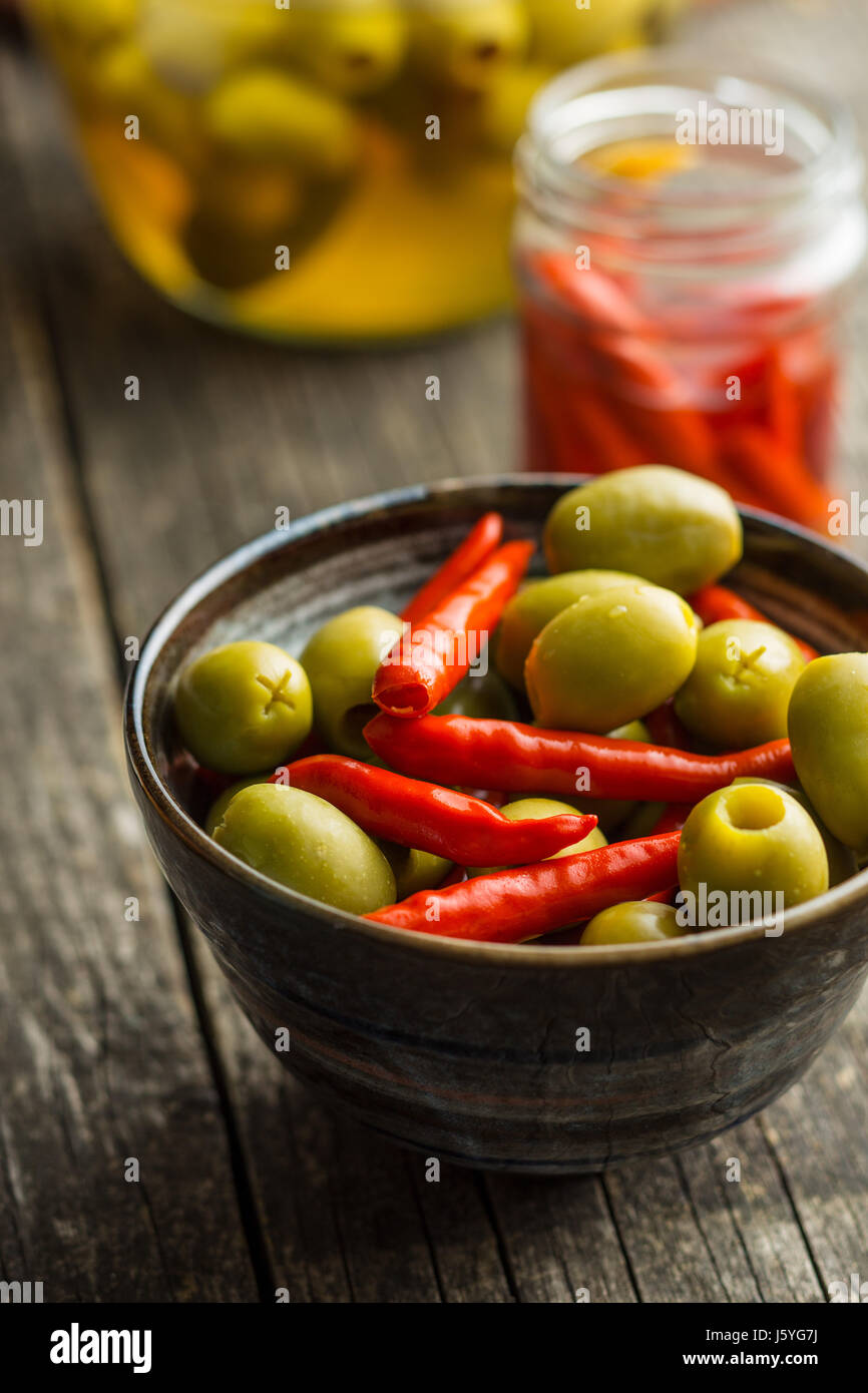 Pickled chili peppers and green olives in bowl Stock Photo Alamy