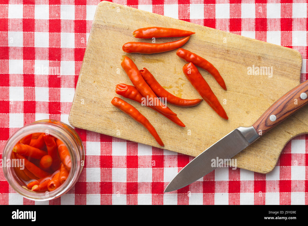 Pickled chili peppers on cutting board Stock Photo - Alamy