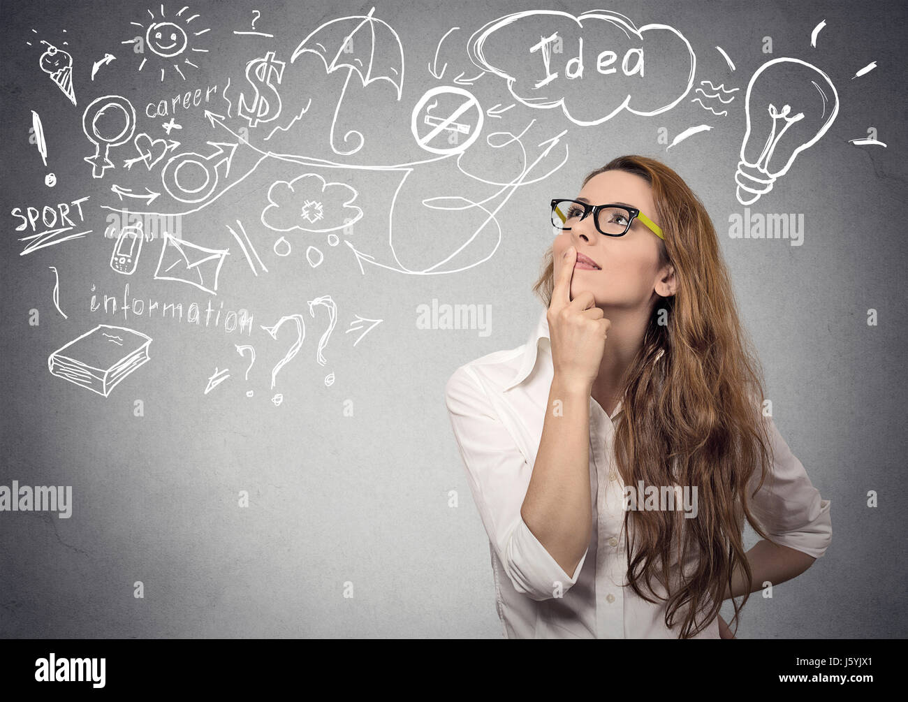 Portrait happy young woman thinking dreaming has many ideas looking up isolated grey wall background. Positive human face expression emotion feeling l Stock Photo
