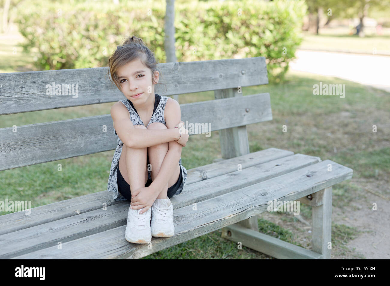 Girl sitting on a wooden bench in a park of Alicante in Spain Stock ...