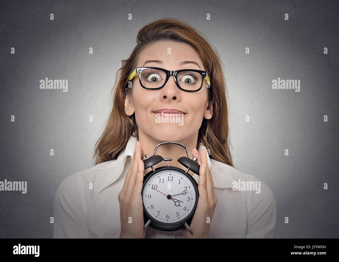 alarm clock. headshot young excited funny looking business woman