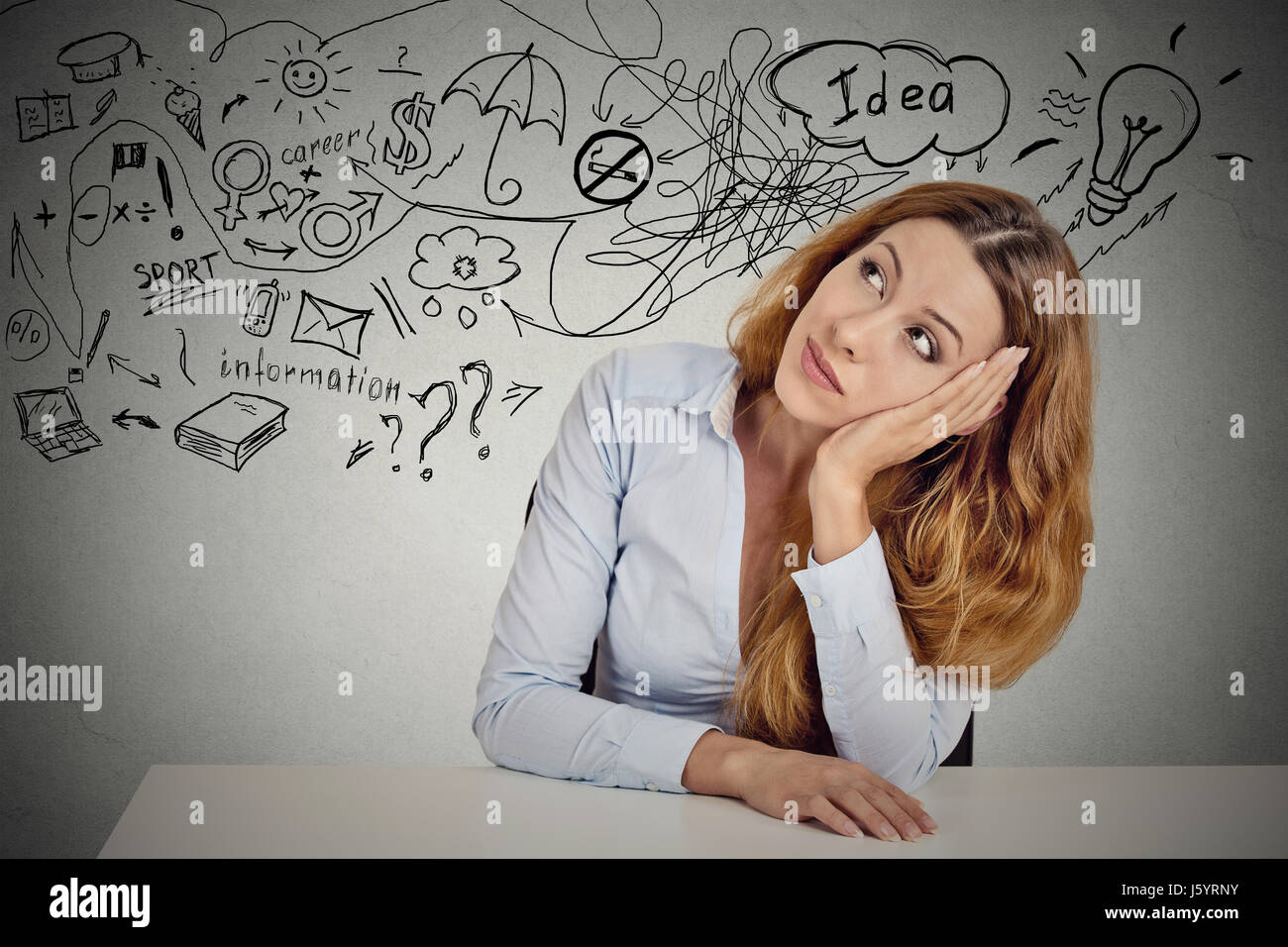 Business woman sitting at table has many ideas things to do planning future isolated grey office wall background. Perception of career. Personal life  Stock Photo