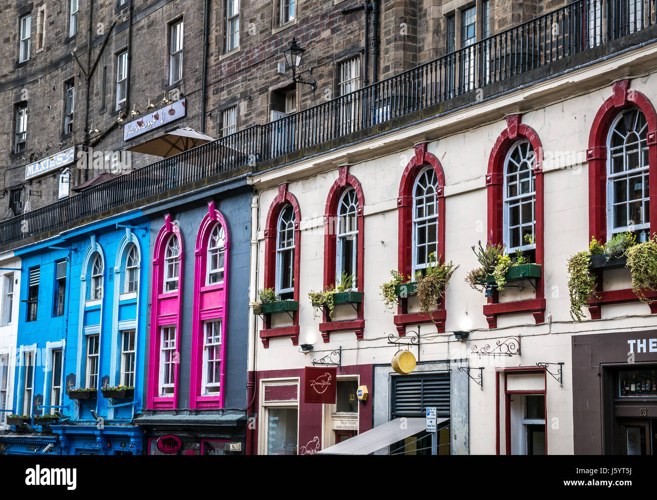 Colourful row of arched windows overlooking Victoria Street, Old Town, Edinburgh, Scotland, UK, with row of shops Stock Photo